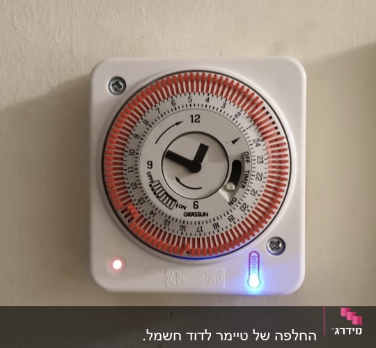 שעון טיימר חשמלי עם מחוגים על קיר